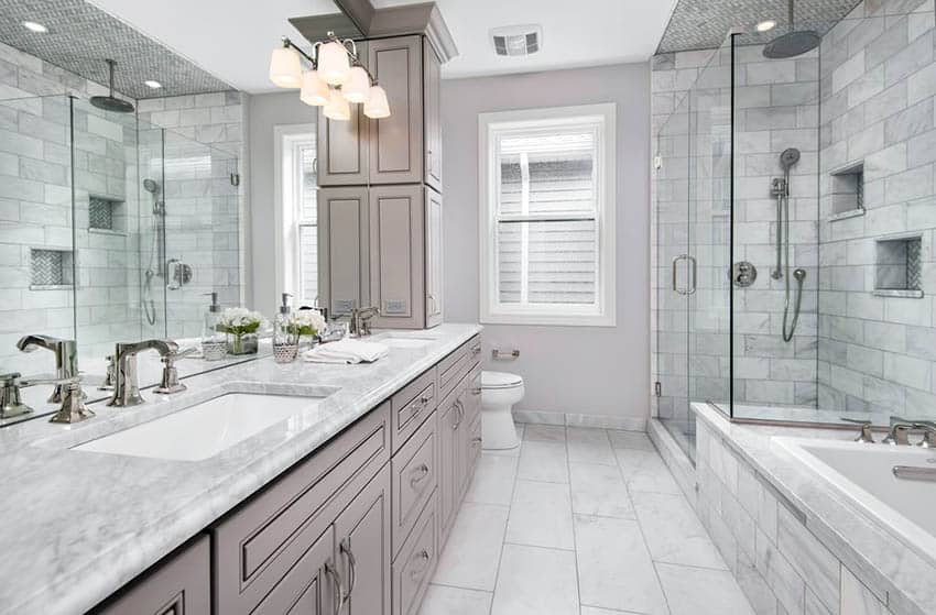 Salle de bain principale avec meuble-lavabo en marbre doré Calacatta et carrelage métro Carrare dans la douche